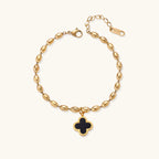 18K gold-plated oval bead bracelet with a four-leaf clover charm in mother-of-pearl or black enamel, adjustable lobster clasp, on white background.