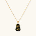 18k gold-plated necklace and earrings with green amber pendants featuring golden inclusions on cream background