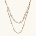 Layered gold chain necklace with organic baroque freshwater pearls and adjustable length on cream background