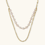Layered gold chain necklace with organic baroque freshwater pearls and adjustable length on cream background