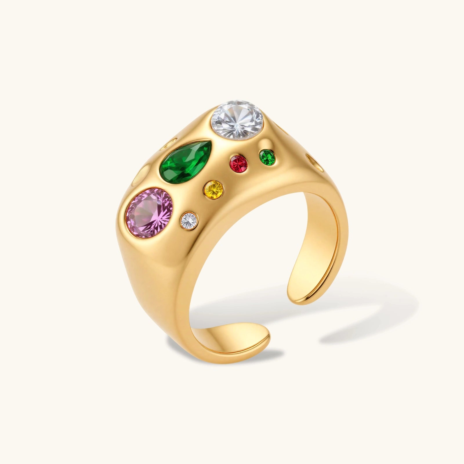 Gold-plated adjustable dome ring with pink, green, white, red, and yellow cubic zirconia stones on cream background.