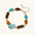 Mixed-material bracelet with turquoise stones, wooden beads, and 18k gold-plated copper elements on white background.