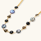 18k gold-plated chain necklace featuring lustrous baroque pearls, black onyx rounds, and smoky quartz triangular stones on white background.