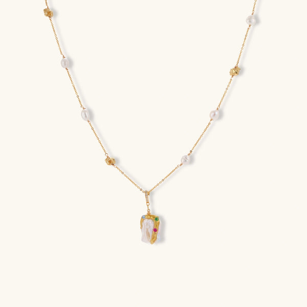 Delicate 18k gold-plated chain with baroque pearls and colorful enamel pendant featuring blue, pink accents on cream background.