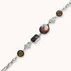 Chain bracelet with amber stones, baroque pearl, and dark rectangular stone on white gold-plated copper base.