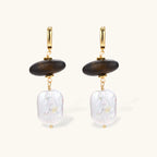 Gold hoop earrings with dark wood beads and baroque freshwater pearls, shown from multiple angles on cream background.
