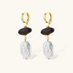 Gold hoop earrings with dark wood beads and baroque freshwater pearls, shown from multiple angles on cream background.